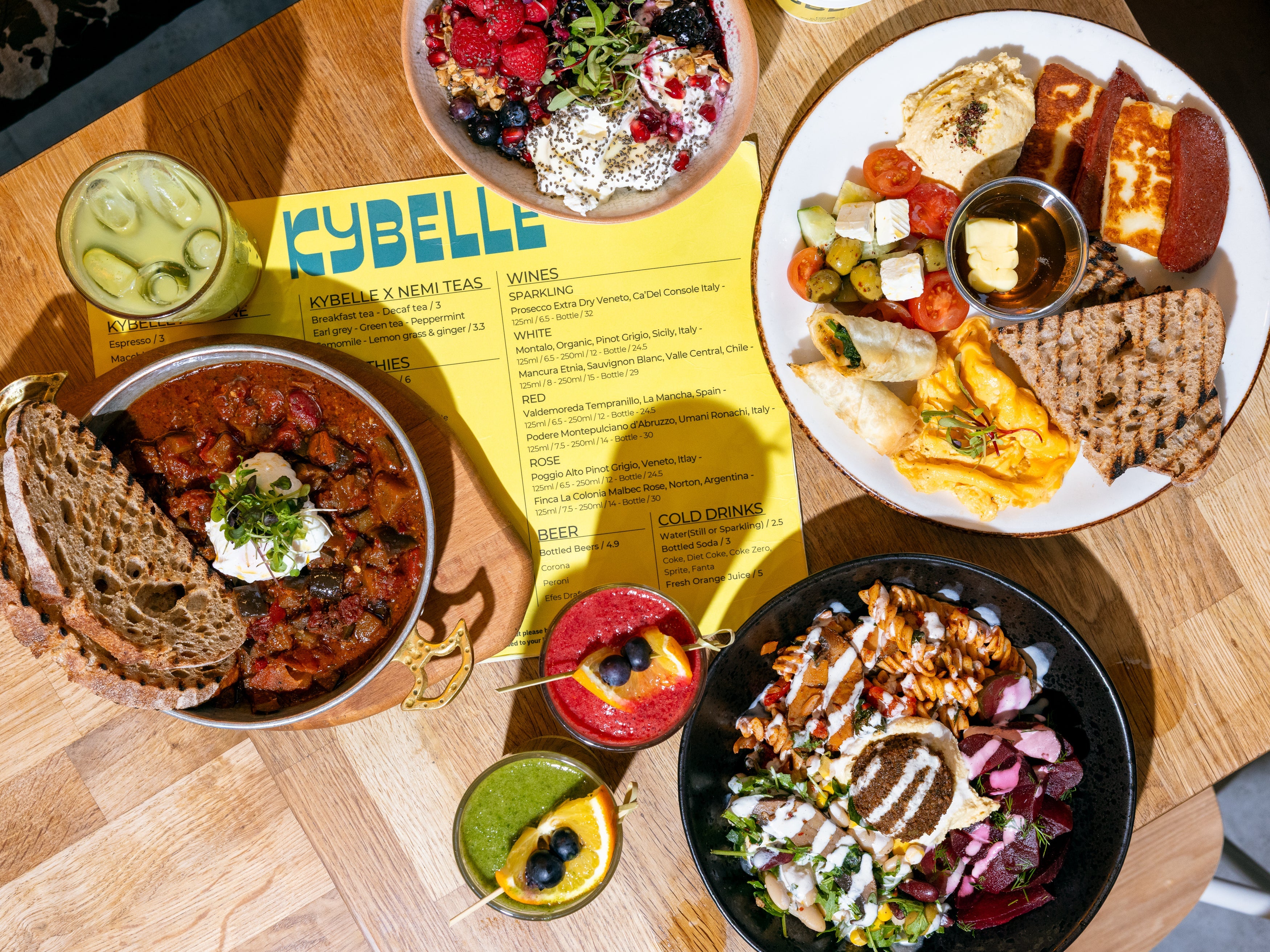 Weekend brunch spread with shakshuka, halloumi breakfast plate, granola bowl and cold drinks at Kybelle Café, Shoreditch