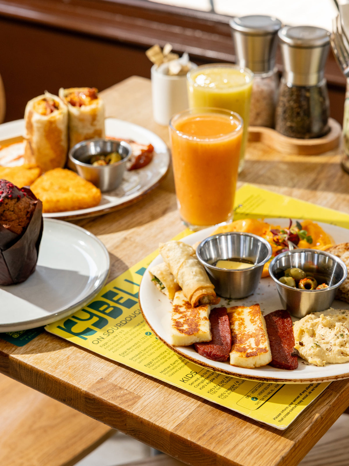 Turkish breakfast spread with grilled halloumi, sujuk, börek, olives and fresh juice at Kybelle Café, Shoreditch